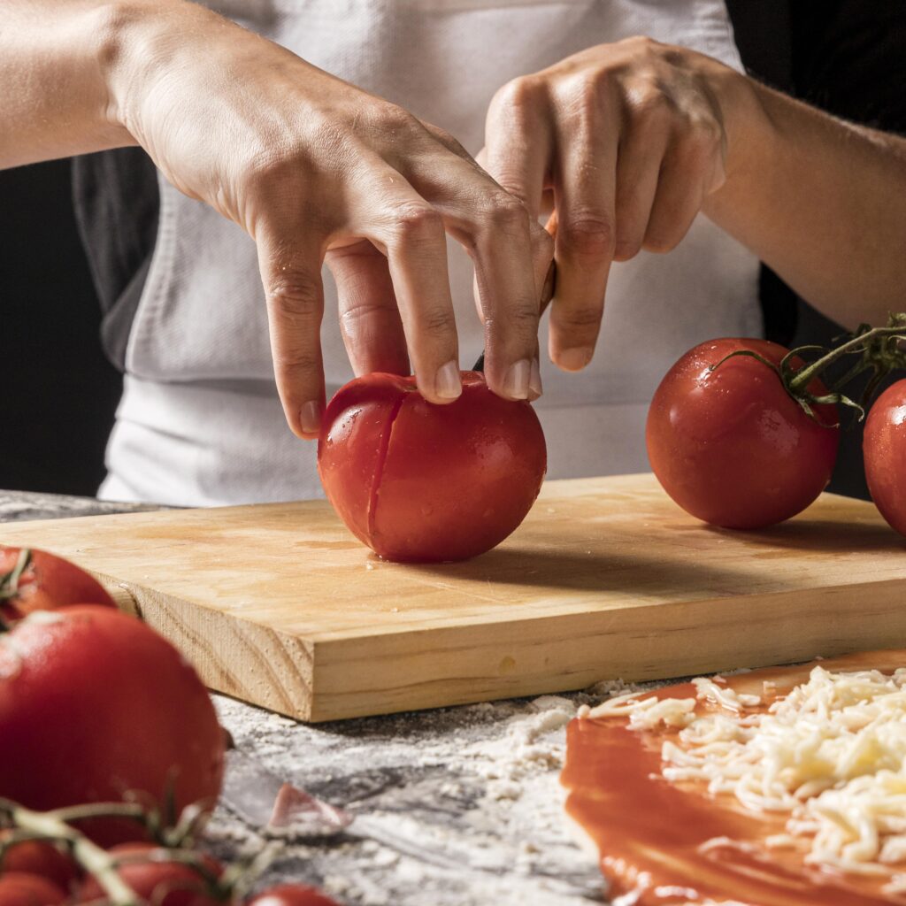 close up hands cutting tomato